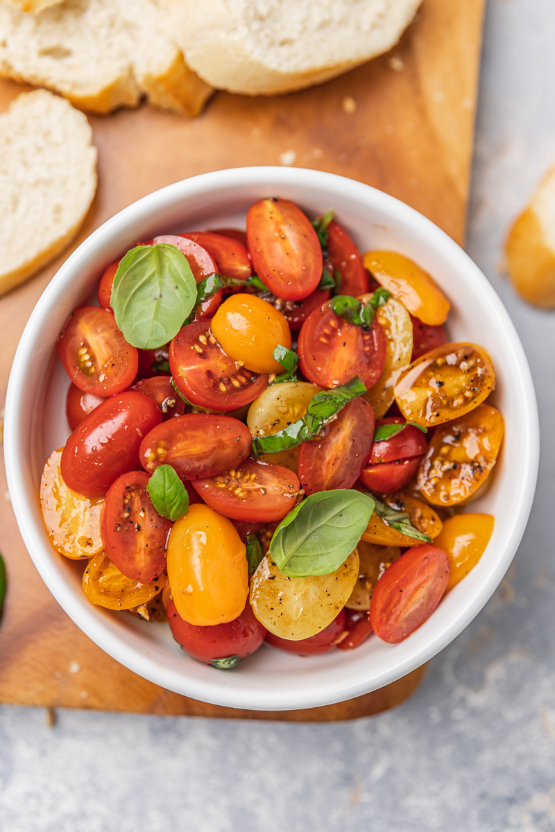 marinated tomatoes with crostini on a serving board.