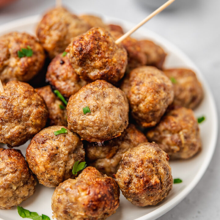 a plate of cooked meatballs with toothpick.