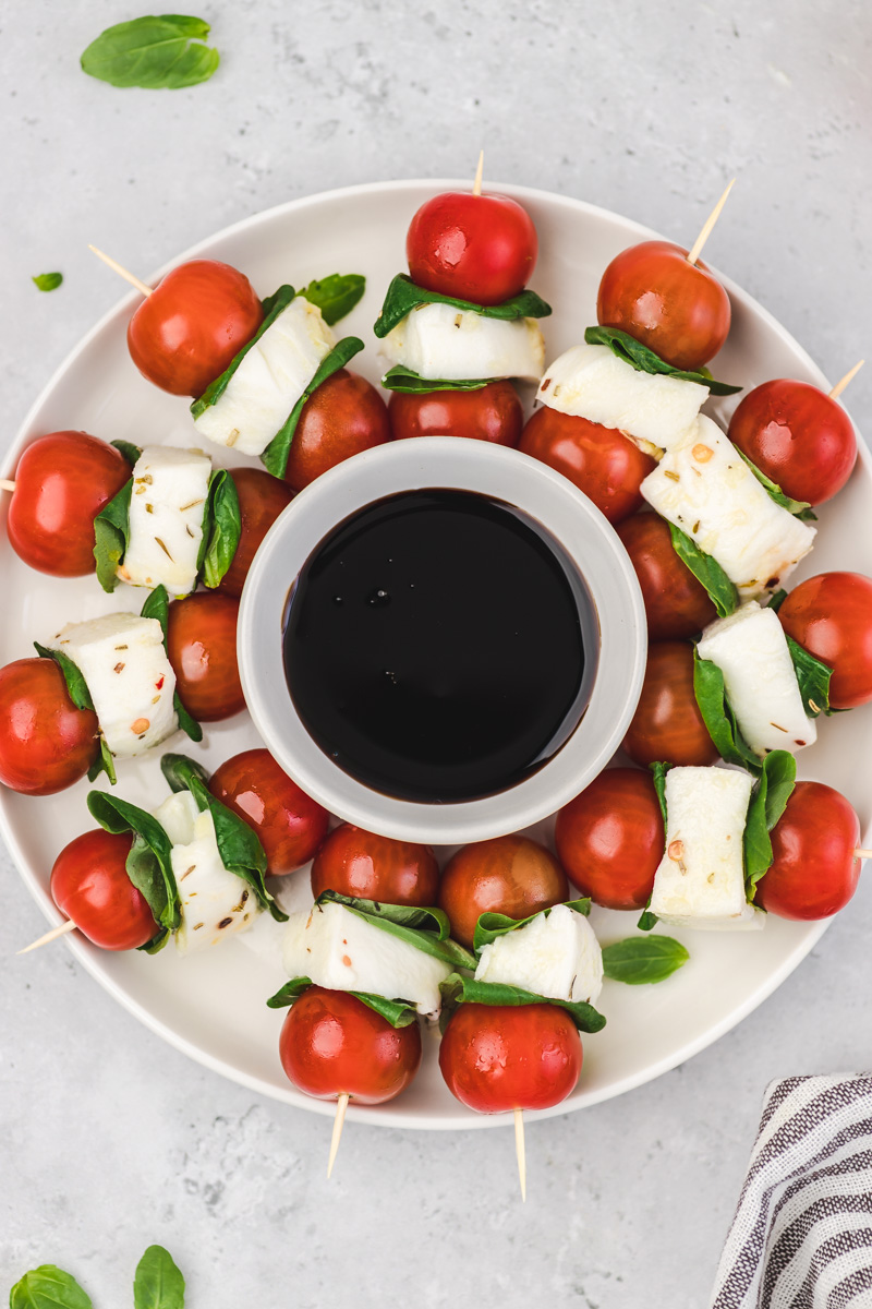 a white platter of caprese kabobs.