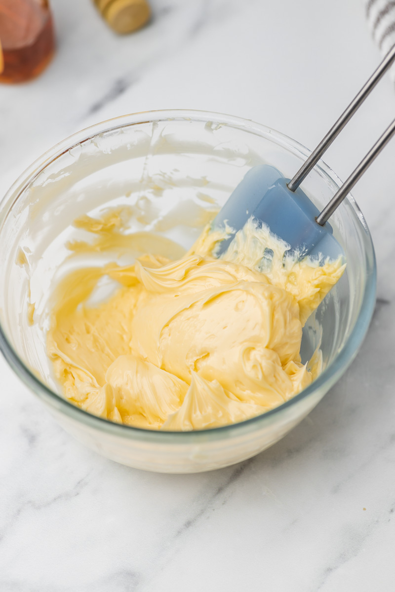 butter in a bowl with a blue spatula.