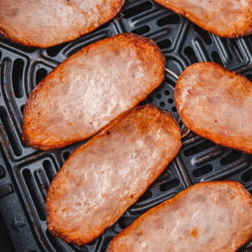 cooked turkey bacon rashers in air fryer basket.