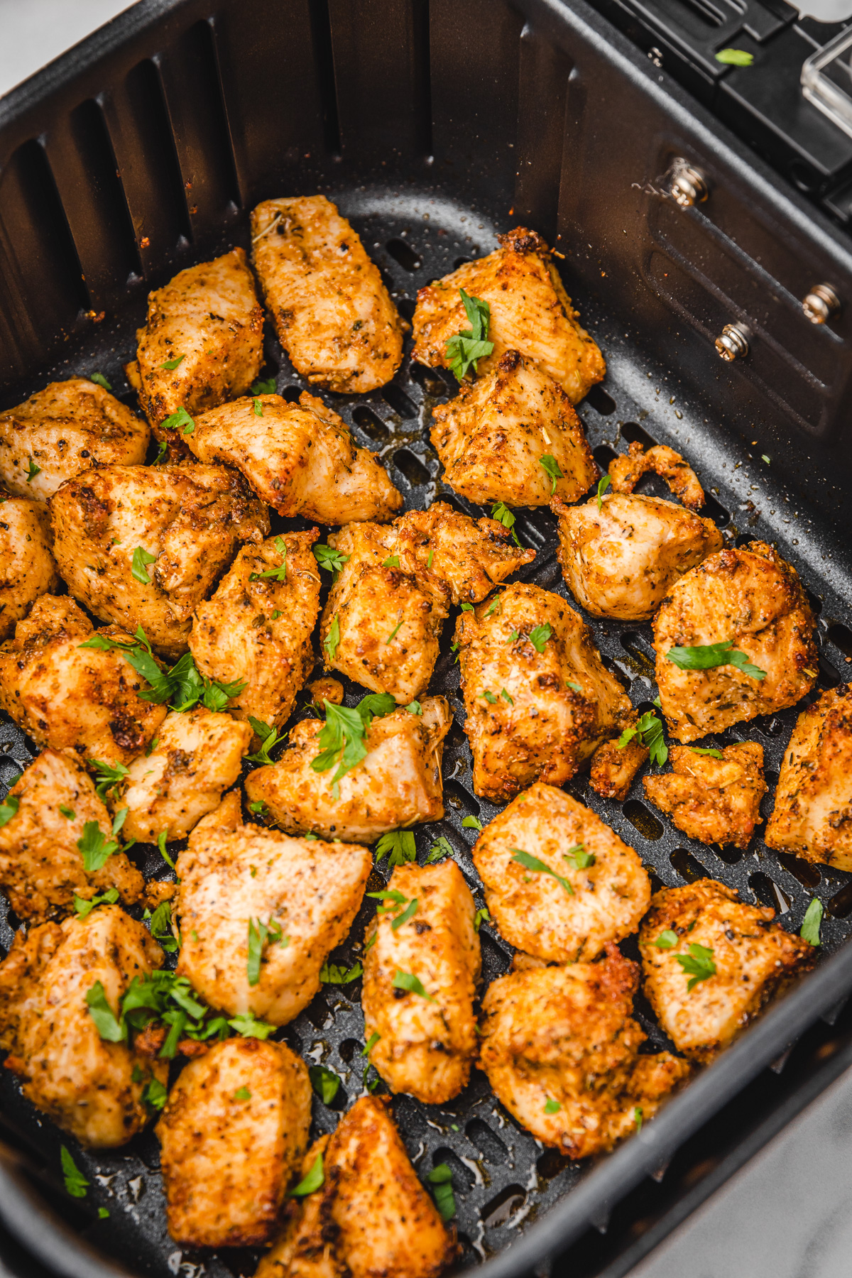 chicken bites in air fryer basket.