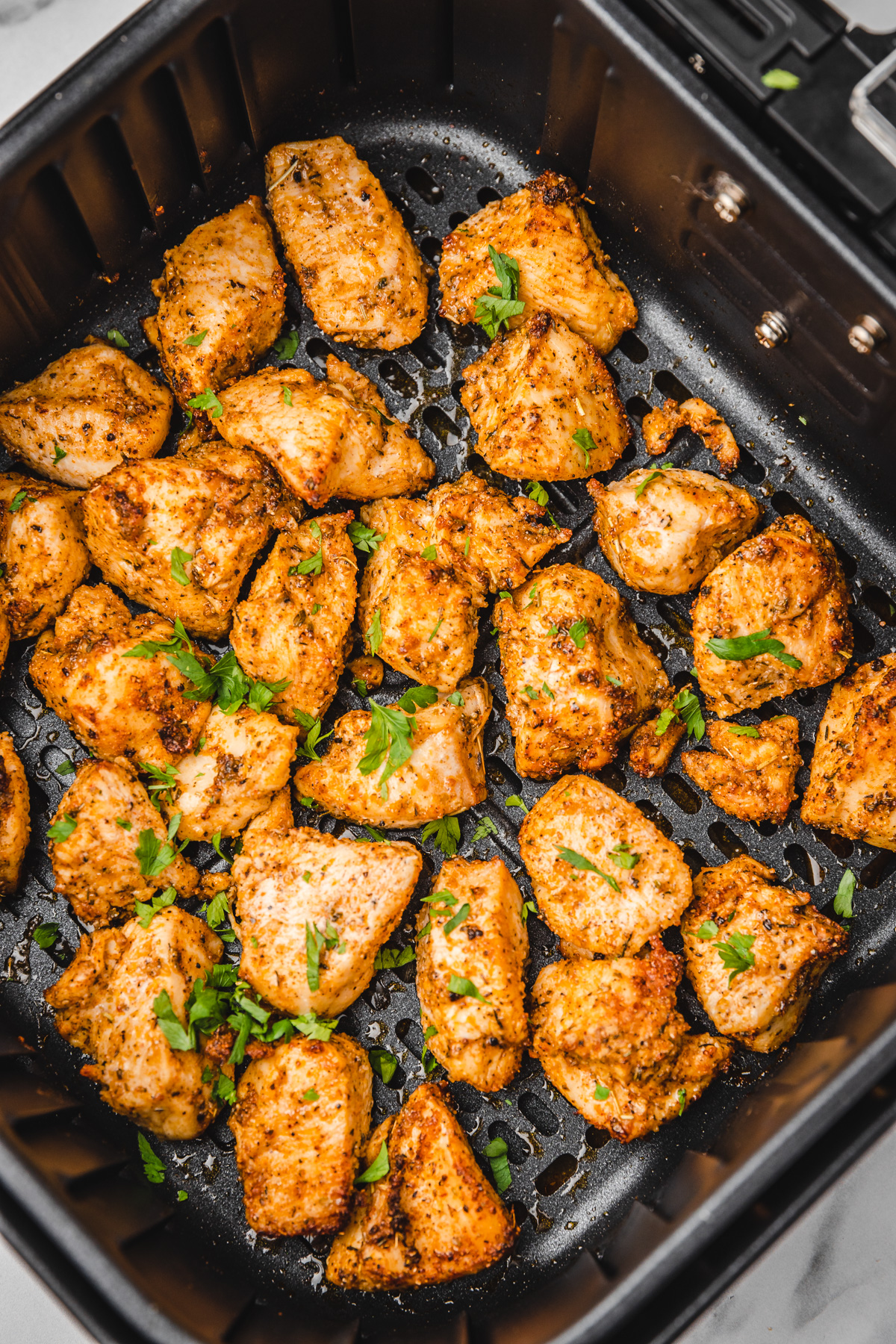 chicken bites in air fryer basket.