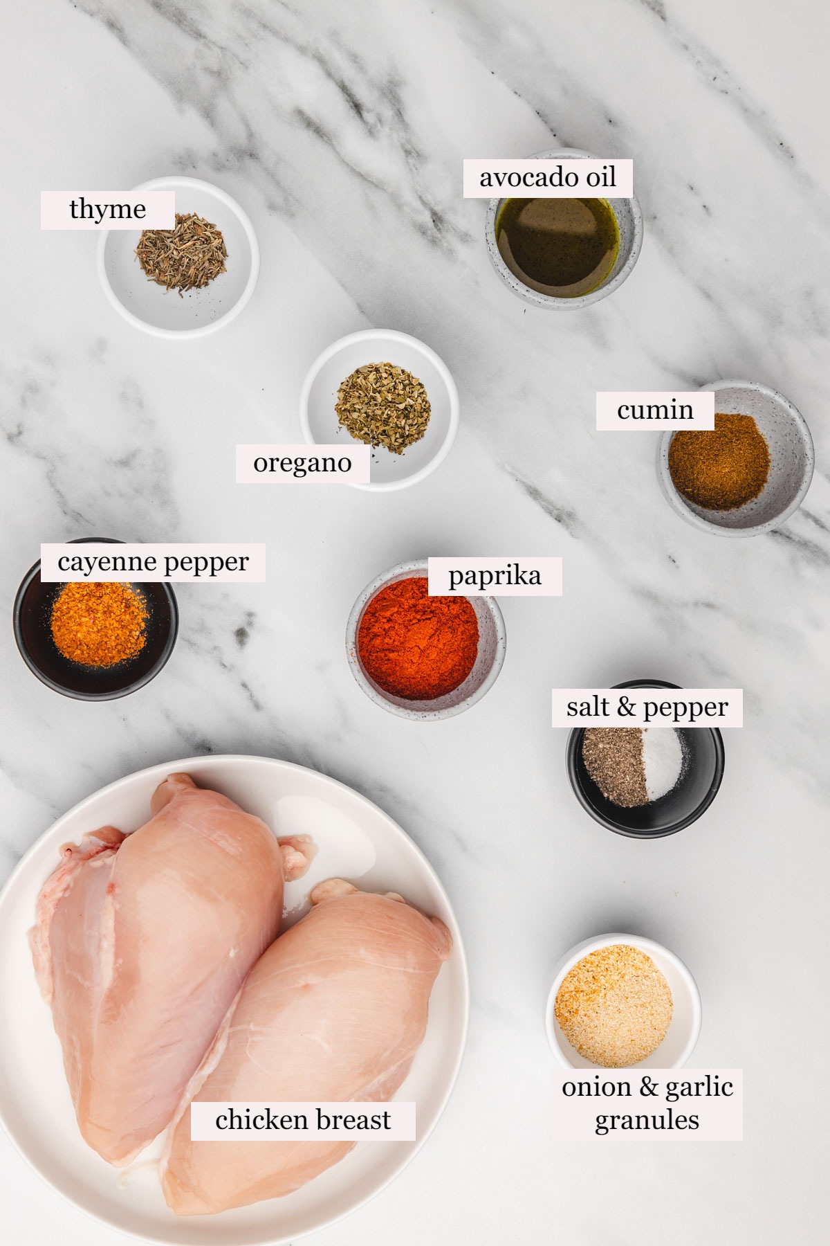ingredients for blackened chicken on a white marbles surface.