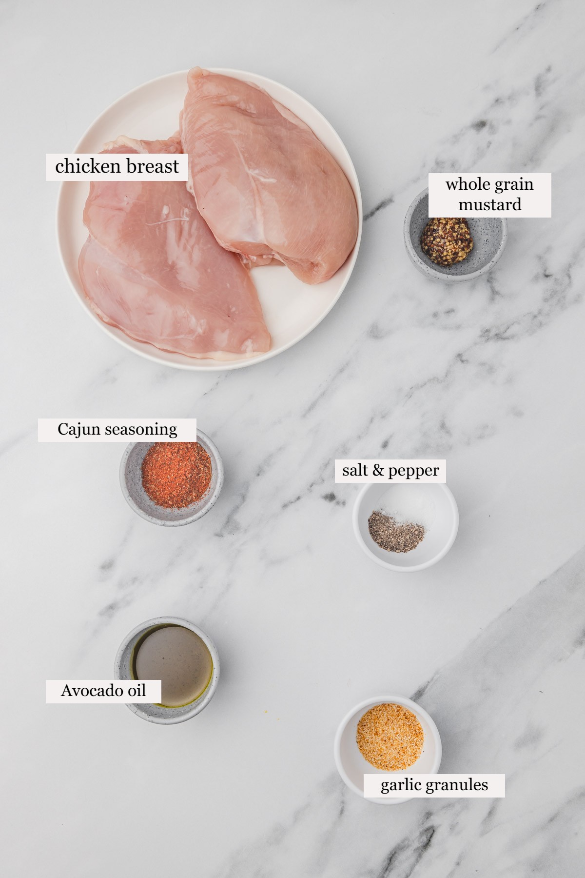 ingredients to make chicken on a white marble surface.