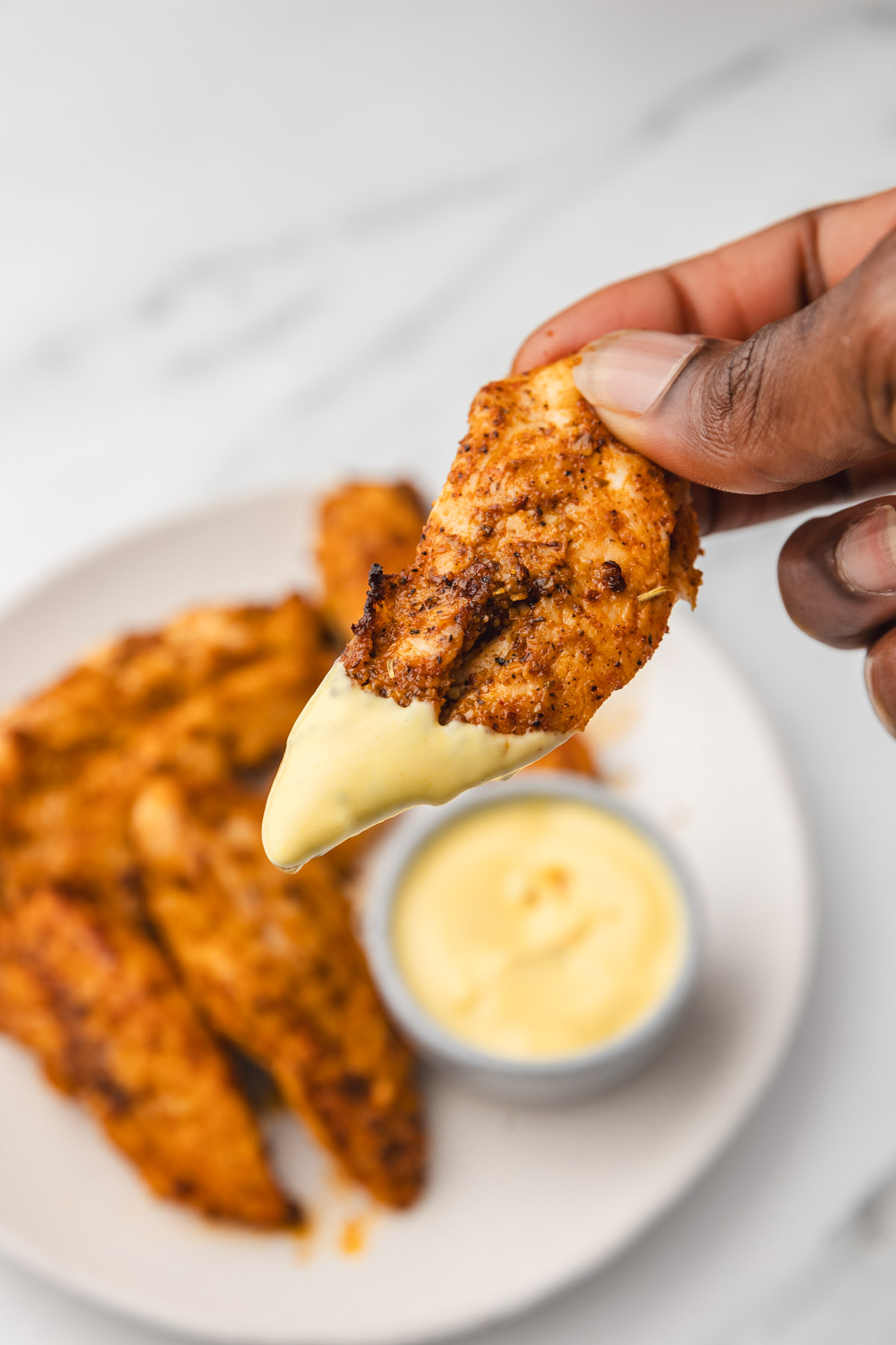 chicken strip dipped in sauce.