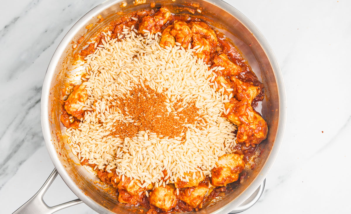 orzo and seasoning in a skillet.