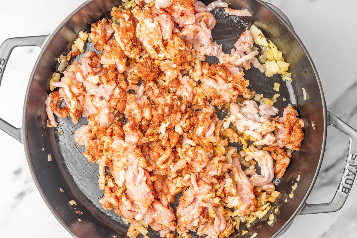 cooking ground chicien in a skillet.