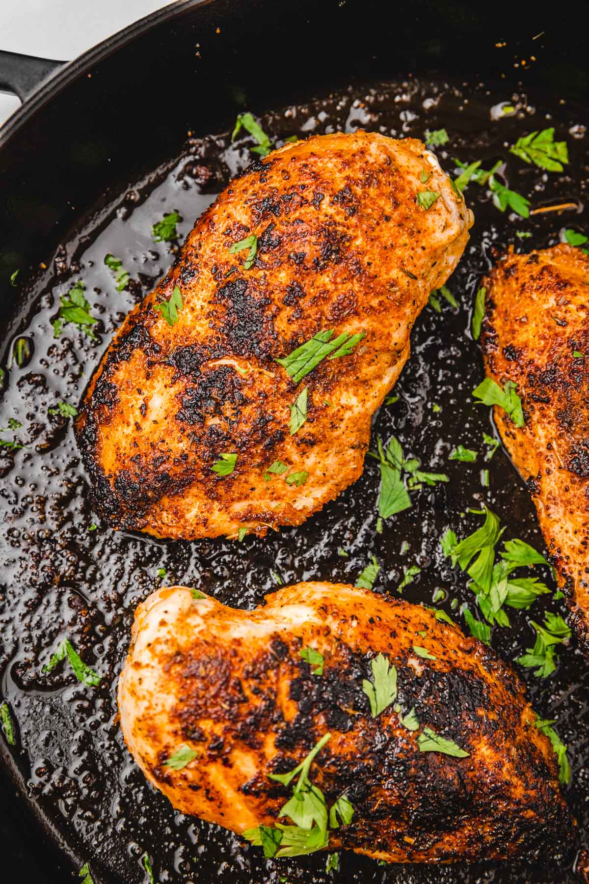 chicken breast garnished with chopped parsley.