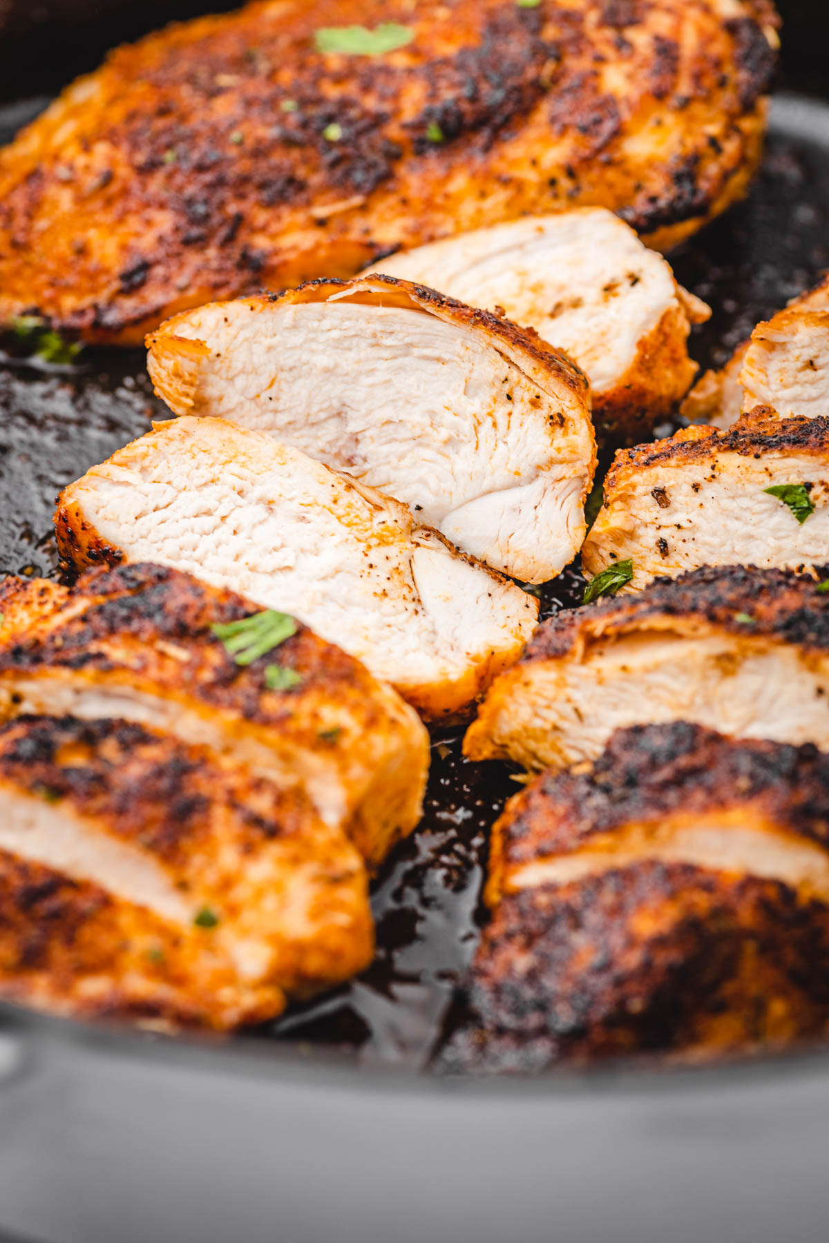 sliced chicken breasts in a cast iron skillet.