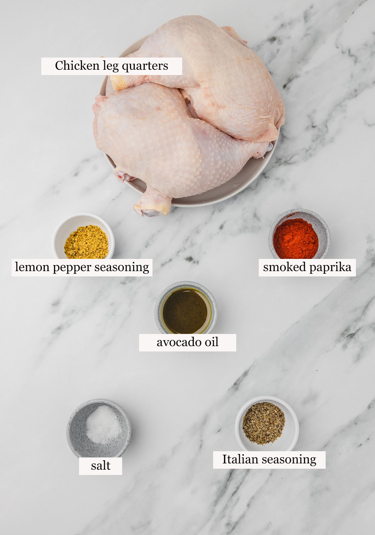 ingredients to season chicken legs on a white marble surface.