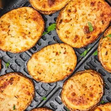 potato slices in an air fryer basket.
